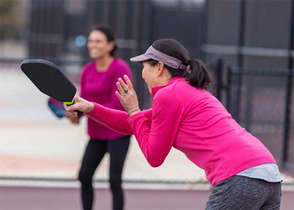 ladies partners playeing pickleball